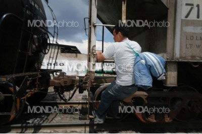 A migrant runs to catch a northbound train leaving the Tultitlan railyard.